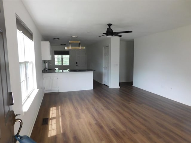 1411 Cresent St, Bentonville, AR 72712 - unfurnished living room featuring dark wood-type flooring, ceiling fan, and a sink