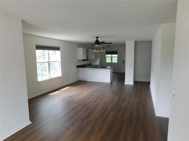 1411 Cresent St, Bentonville, AR 72712 - unfurnished living room with dark wood-type flooring, baseboards, and ceiling fan
