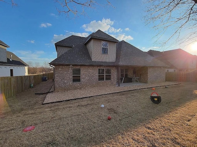 4202 SW Plumley Ave, Bentonville, AR 72713 - back of property with a patio area, a fenced backyard, brick siding, and roof with shingles