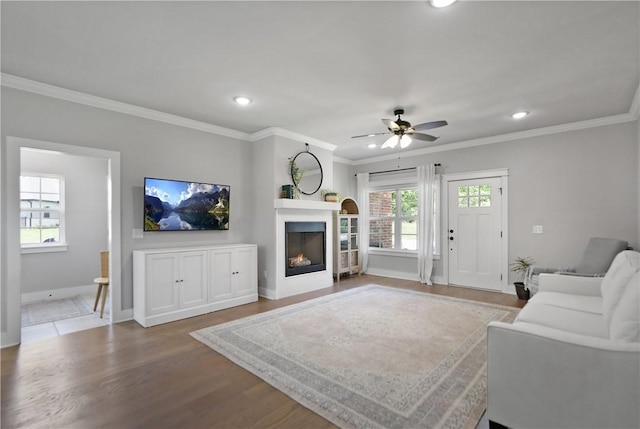 3 Francis Dr, Bella Vista, AR 72715 - living room featuring recessed lighting, baseboards, ceiling fan, a warm lit fireplace, and wood finished floors