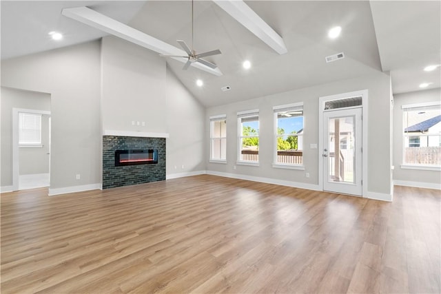 unfurnished living room featuring high vaulted ceiling, ceiling fan, a glass covered fireplace, baseboards, and light wood finished floors