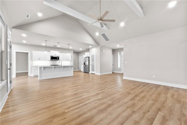 unfurnished living room with high vaulted ceiling, ceiling fan, recessed lighting, beamed ceiling, and light wood-type flooring