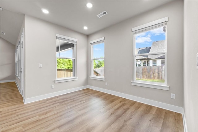 spare room featuring light wood finished floors, baseboards, and recessed lighting