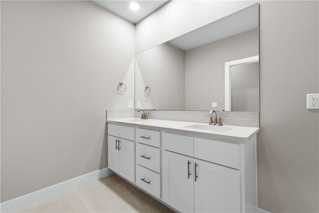 full bathroom featuring double vanity, tile patterned flooring, and baseboards