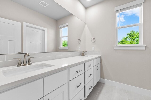 full bathroom featuring tile patterned floors, baseboards, and double vanity