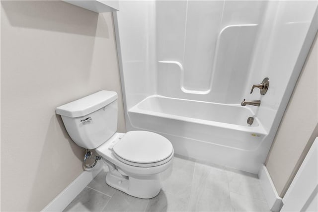 bathroom featuring baseboards, toilet, and bathing tub / shower combination
