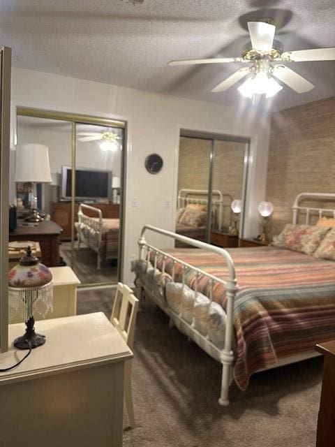 bedroom featuring multiple closets, carpet flooring, a ceiling fan, and a textured ceiling