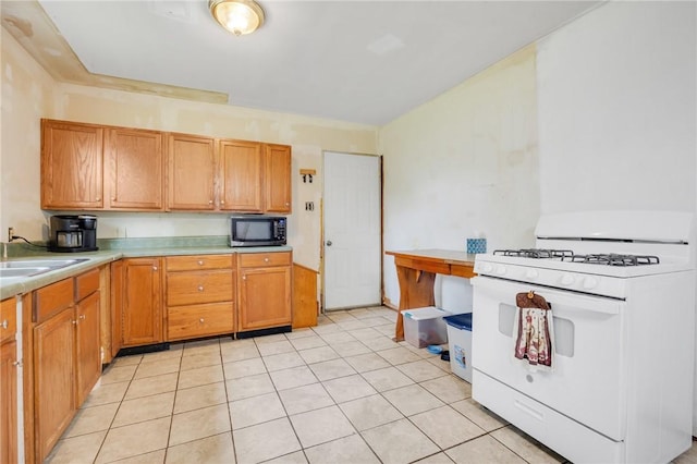 1014 Alma Ave, Mulberry, AR 72947 - kitchen featuring white range with gas stovetop, black microwave, a sink, light countertops, and light tile patterned flooring