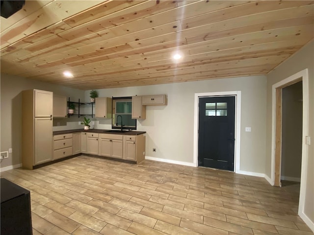 kitchen featuring dark countertops, a sink, light wood-type flooring, baseboards, and open shelves