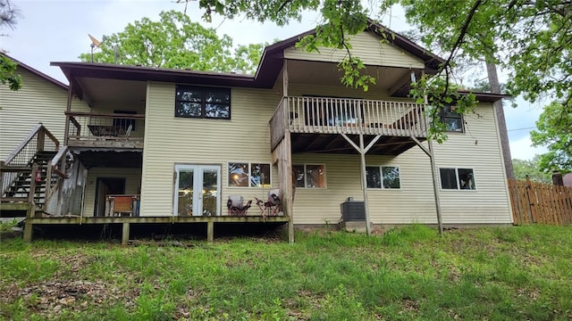 rear view of house with a balcony, fence, and central AC