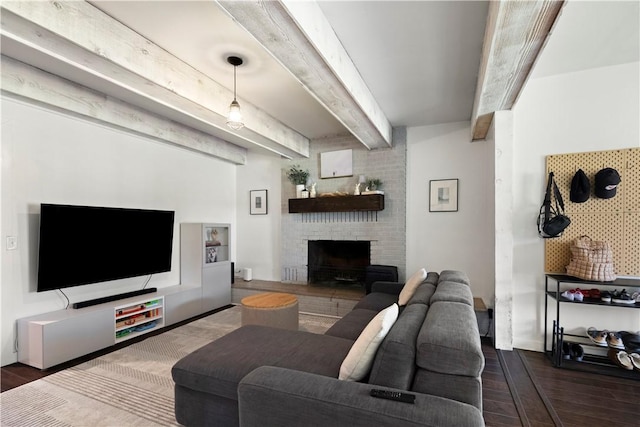 living room with wood finished floors, a brick fireplace, and beamed ceiling
