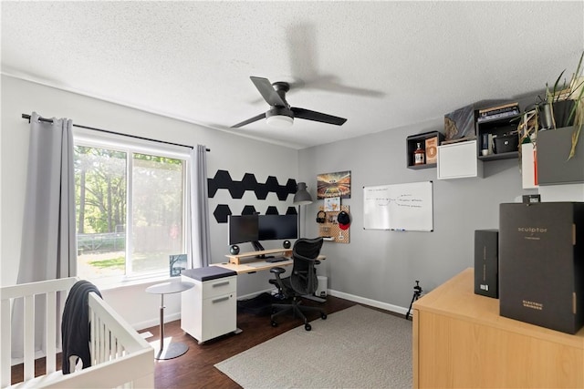 office with a ceiling fan, dark wood-style floors, a textured ceiling, and baseboards