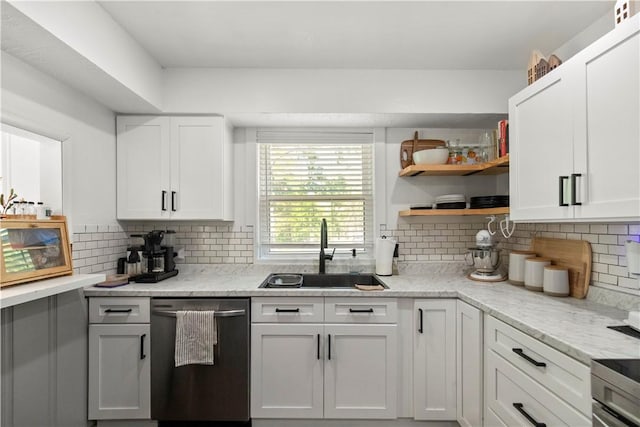 kitchen with stainless steel dishwasher, a sink, white cabinetry, and backsplash