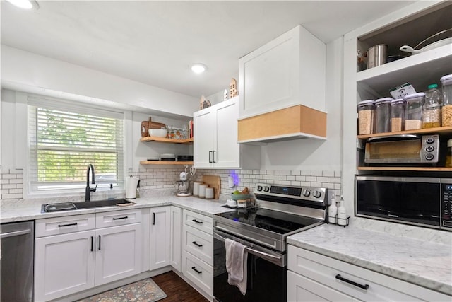 kitchen with open shelves, stainless steel appliances, a sink, white cabinets, and tasteful backsplash