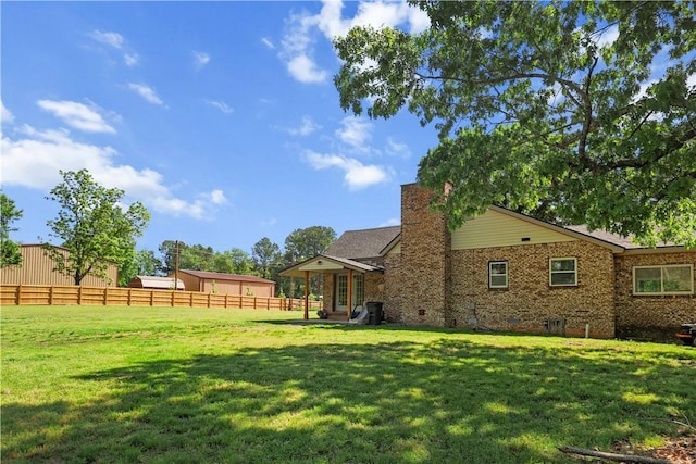 back of house with brick siding, a chimney, and crawl space