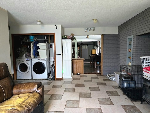 2711 Aspen Ln, Rogers, AR 72758 - laundry area with brick wall, a barn door, separate washer and dryer, and a textured ceiling