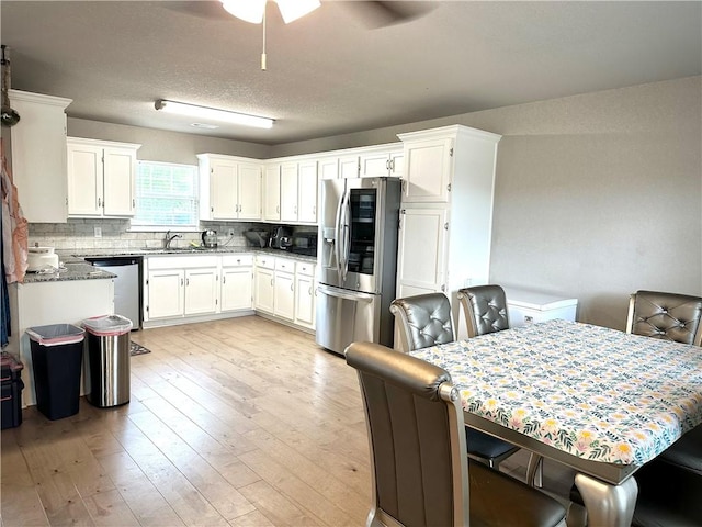 1213 Crutcher St, Springdale, AR 72764 - kitchen with stainless steel appliances, a sink, ceiling fan, white cabinets, and light wood finished floors