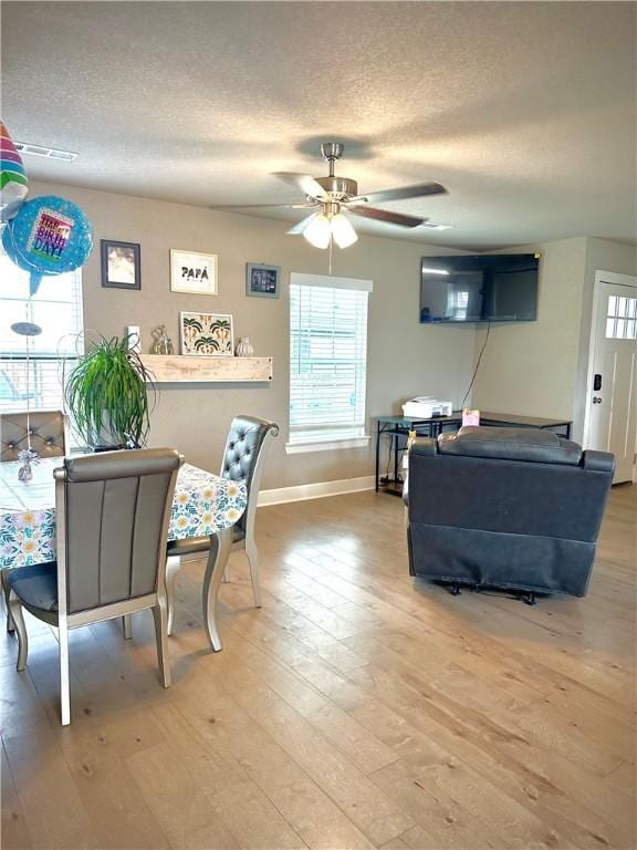 1213 Crutcher St, Springdale, AR 72764 - dining space with a textured ceiling, baseboards, light wood-style flooring, a ceiling fan, and healthy amount of natural light