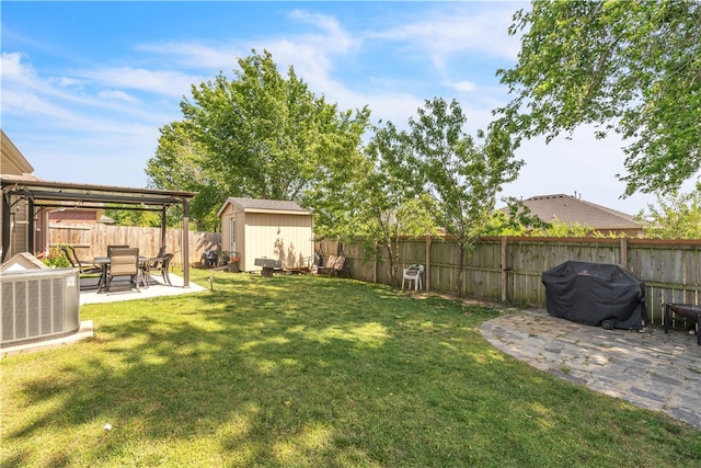 view of yard featuring central AC unit, a patio area, a storage shed, and an outdoor structure