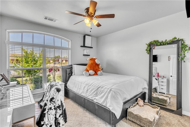 bedroom with a ceiling fan and light colored carpet