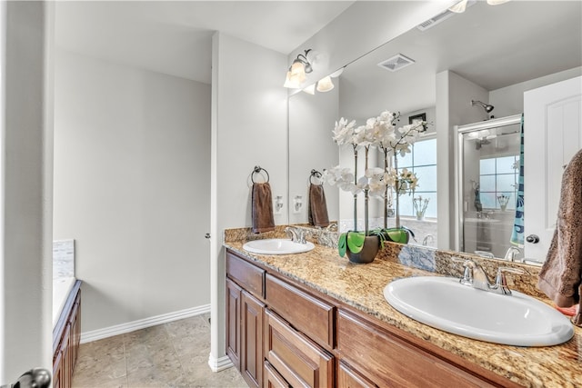 full bathroom with a stall shower, double vanity, and baseboards