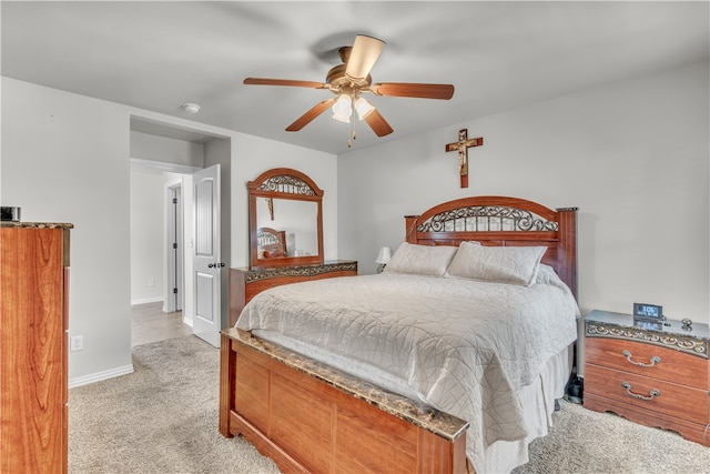 bedroom featuring light carpet, baseboards, and a ceiling fan