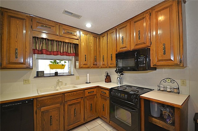 3001 Mcdonald Ave, Springdale, AR 72762 - kitchen featuring black appliances, a sink, brown cabinetry, light countertops, and a textured ceiling
