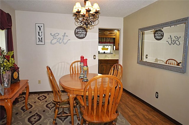 3001 Mcdonald Ave, Springdale, AR 72762 - dining space featuring a chandelier, wood finished floors, baseboards, and a textured ceiling