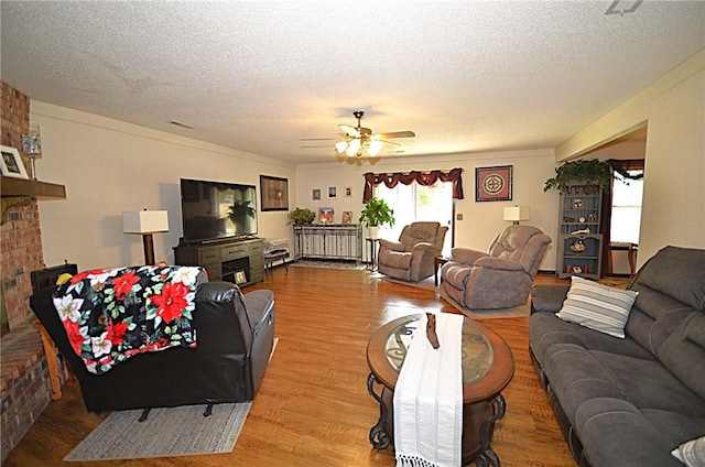 3001 Mcdonald Ave, Springdale, AR 72762 - living area with wood finished floors, a textured ceiling, ceiling fan, and a fireplace
