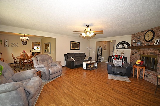3001 Mcdonald Ave, Springdale, AR 72762 - living room featuring wood finished floors, a chandelier, a textured ceiling, ceiling fan, and a brick fireplace
