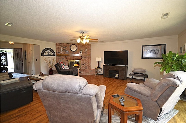 3001 Mcdonald Ave, Springdale, AR 72762 - living area featuring wood finished floors, a ceiling fan, a textured ceiling, and a fireplace