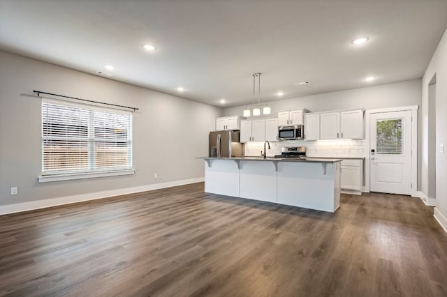 4400 SW Pawhuska St, Bentonville, AR 72713 - kitchen with stainless steel appliances, a breakfast bar, white cabinetry, recessed lighting, and a kitchen island with sink
