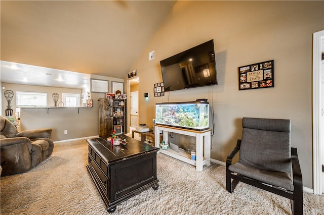 carpeted living area with baseboards and high vaulted ceiling
