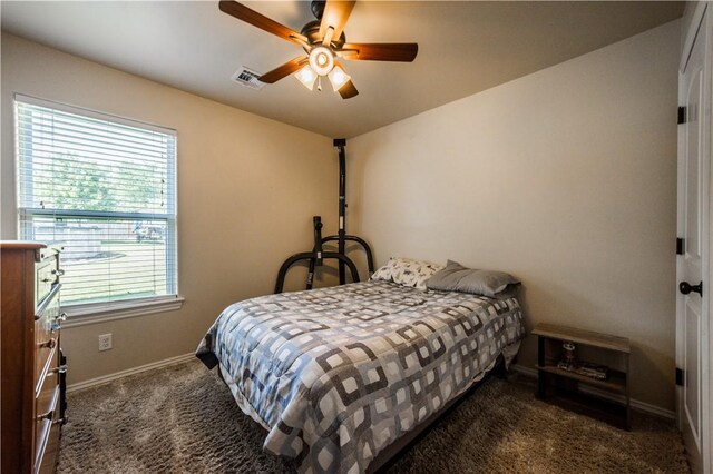 bedroom featuring multiple windows, carpet floors, baseboards, and a ceiling fan