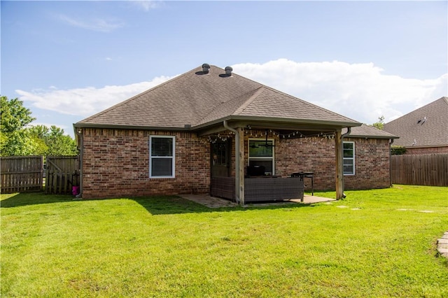 rear view of property featuring brick siding, a shingled roof, and a patio area