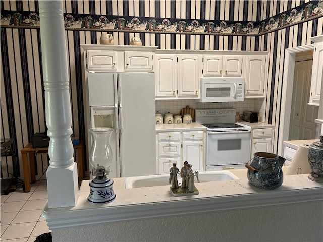 5095 Saxon St, Springdale, AR 72764 - kitchen with white appliances, light tile patterned flooring, white cabinets, a sink, and light countertops