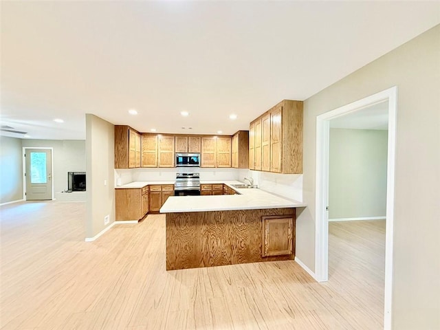 10098 Bayview Rd, Dardanelle, AR 72834 - kitchen featuring stainless steel appliances, brown cabinetry, light wood-type flooring, a peninsula, and open floor plan