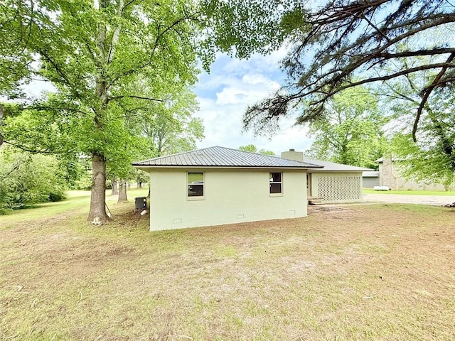10098 Bayview Rd, Dardanelle, AR 72834 - rear view of property featuring a lawn, metal roof, a chimney, and stucco siding