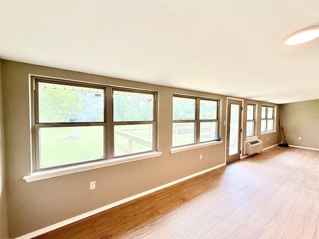 10098 Bayview Rd, Dardanelle, AR 72834 - spare room featuring light wood-style flooring, baseboards, and a wall mounted AC