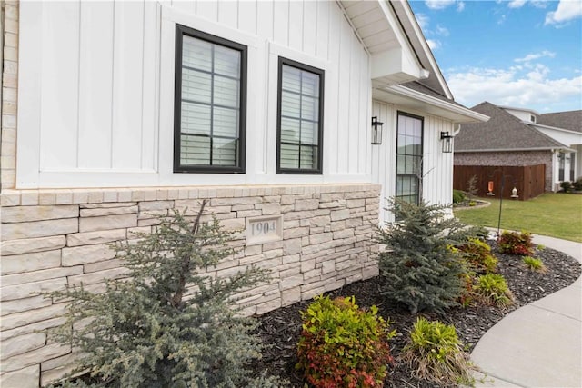 1904 Tull Dr, Pea Ridge, AR 72751 - view of home's exterior with board and batten siding, stone siding, and a lawn