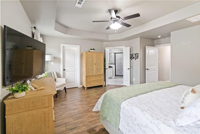 1904 Tull Dr, Pea Ridge, AR 72751 - bedroom featuring dark wood-style floors, a raised ceiling, a ceiling fan, and ensuite bath