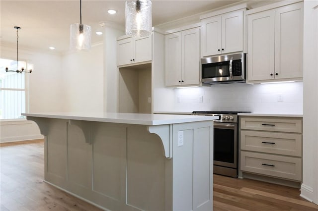 3 Berkshire Dr, Bella Vista, AR 72714 - kitchen featuring stainless steel appliances, light wood-type flooring, a center island, backsplash, and a breakfast bar area