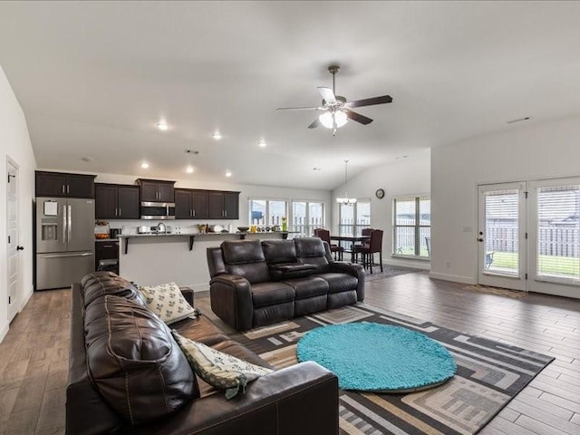 living room featuring light wood-type flooring, ceiling fan, lofted ceiling, recessed lighting, and baseboards