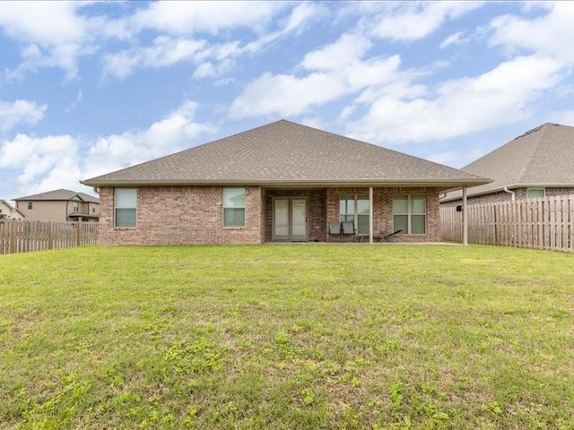 back of house featuring brick siding and roof with shingles