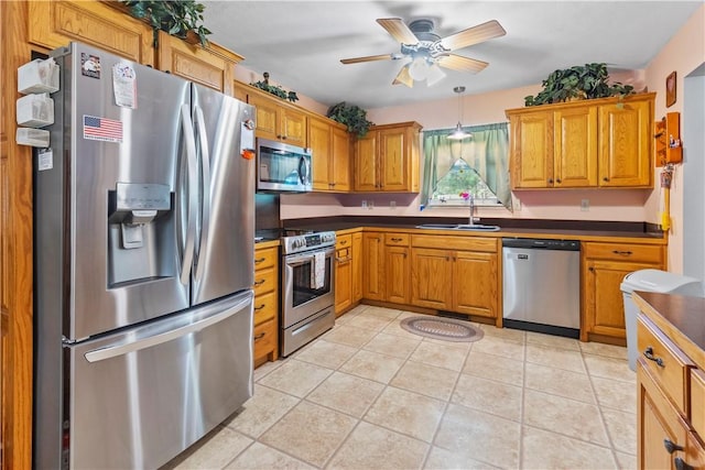3277 Bellefonte Rd, Harrison, AR 72601 - kitchen featuring appliances with stainless steel finishes, a sink, dark countertops, ceiling fan, and brown cabinets