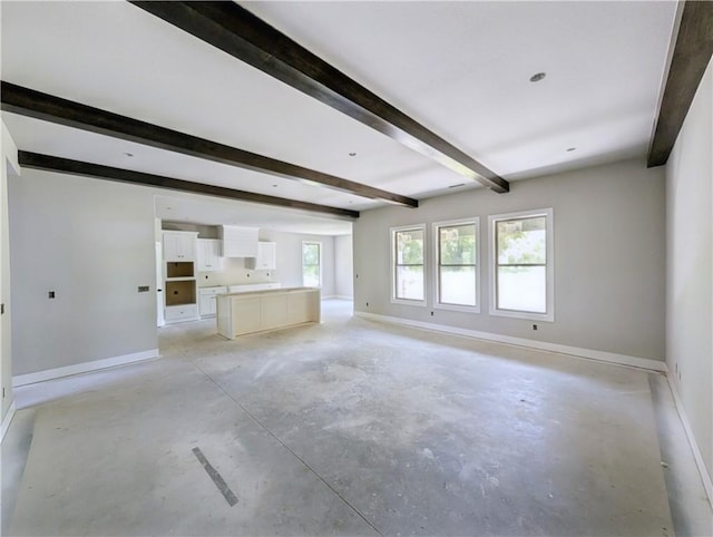 10 Olmsted Cir, Bella Vista, AR 72715 - unfurnished living room with baseboards, beam ceiling, and unfinished concrete floors