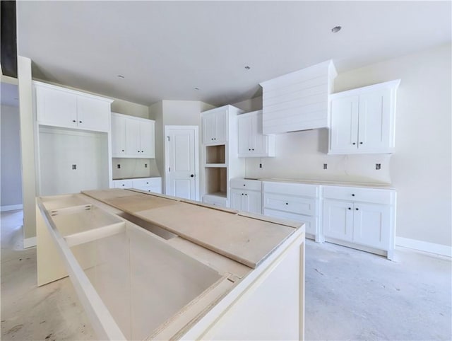 10 Olmsted Cir, Bella Vista, AR 72715 - kitchen featuring a center island, unfinished concrete flooring, white cabinetry, and baseboards