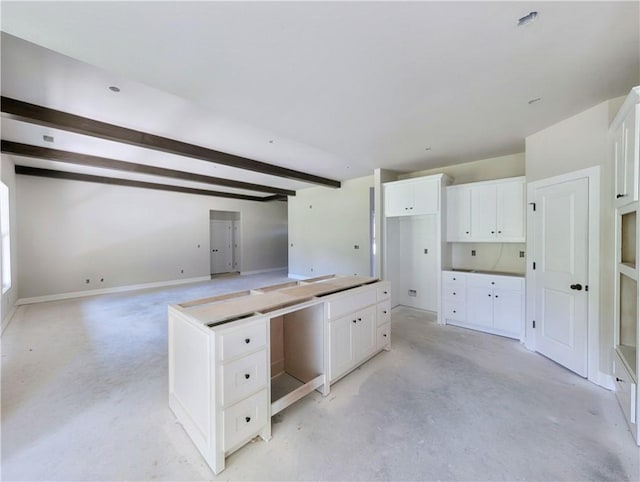 10 Olmsted Cir, Bella Vista, AR 72715 - kitchen with white cabinets, open floor plan, beam ceiling, concrete flooring, and baseboards