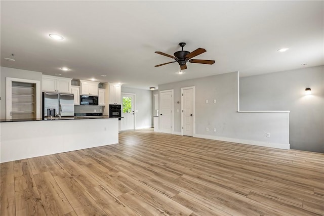 unfurnished living room with a ceiling fan, light wood-style floors, recessed lighting, and baseboards