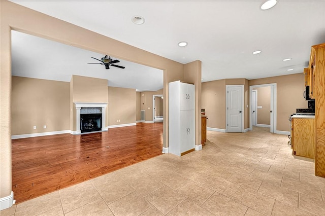 21 Sidlaw Hills Dr, Bella Vista, AR 72715 - unfurnished living room featuring a ceiling fan, baseboards, a fireplace, light wood-style floors, and recessed lighting